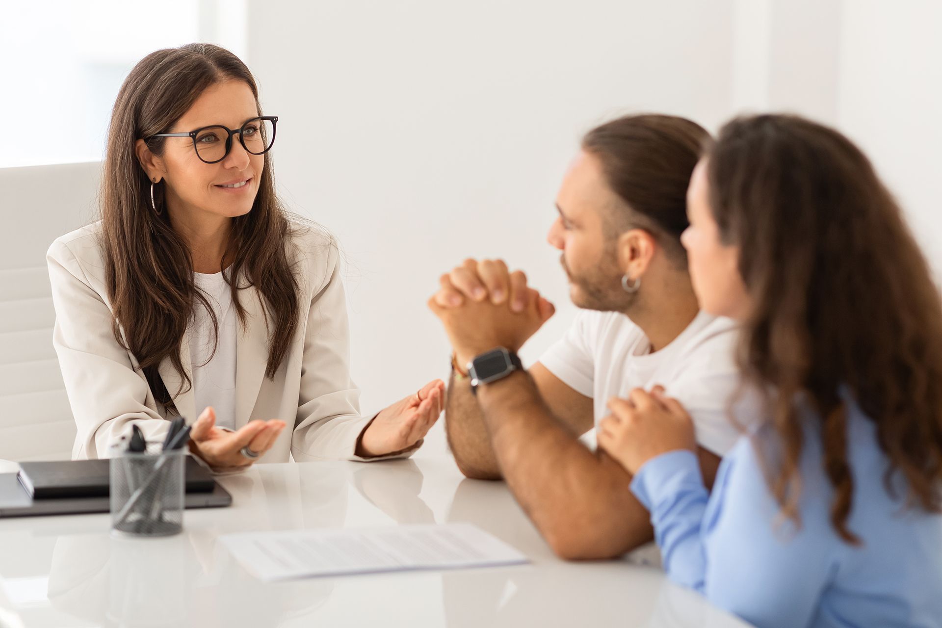 A woman is talking to a man and a woman at a table.