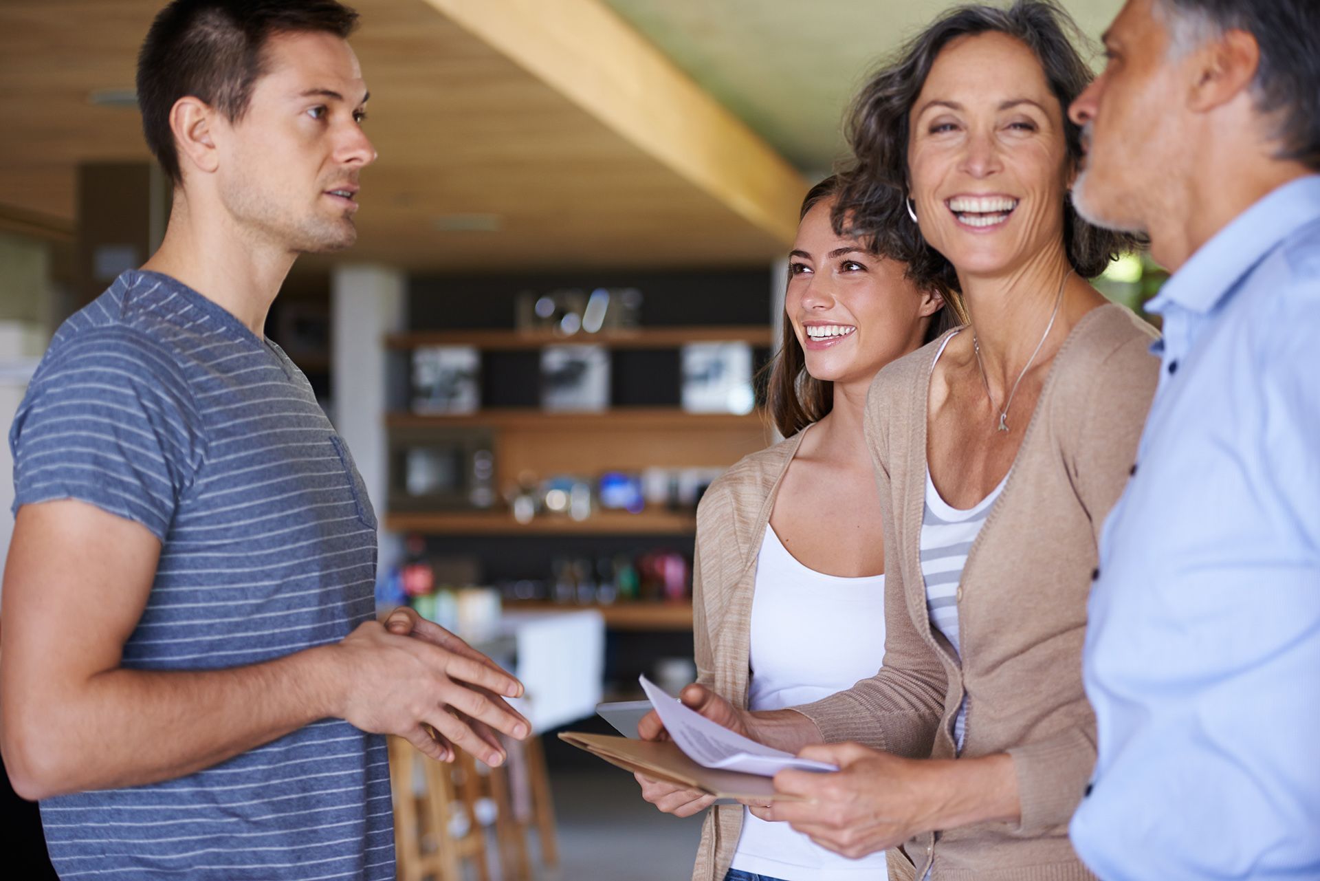 A group of people are standing in a room talking to each other