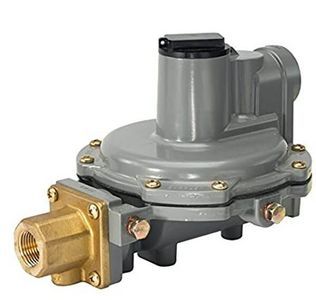 Regulador de gas gris y latón con entrada roscada, utilizado para controlar el flujo de gas.