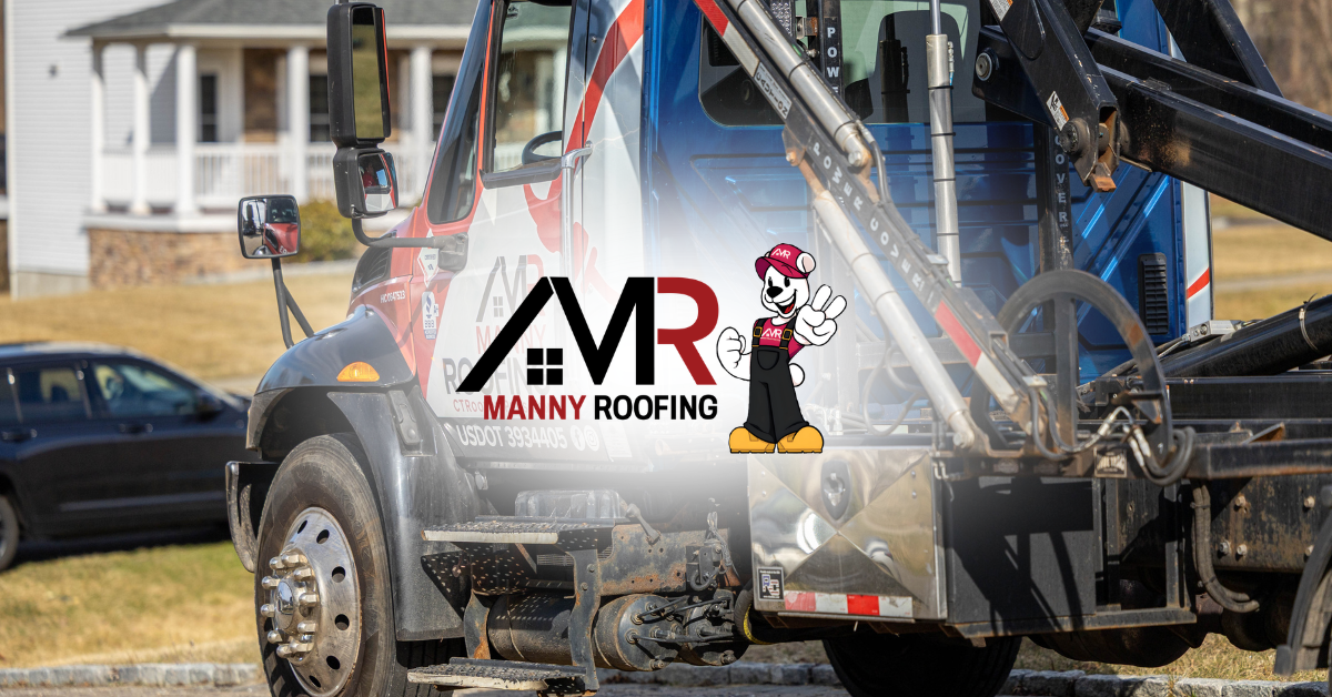 Tow truck with Manny Roofing logo spraying water at a damaged car on a street near houses