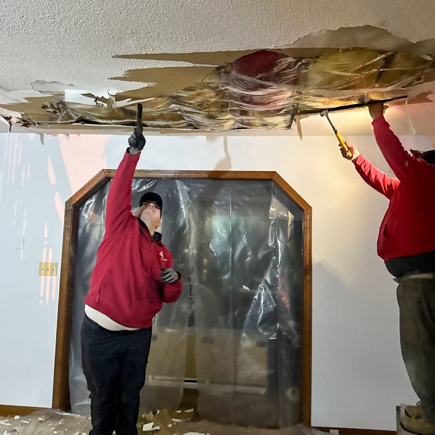 The Manny Roofing team working to restore a room damaged by a serious roof leak.