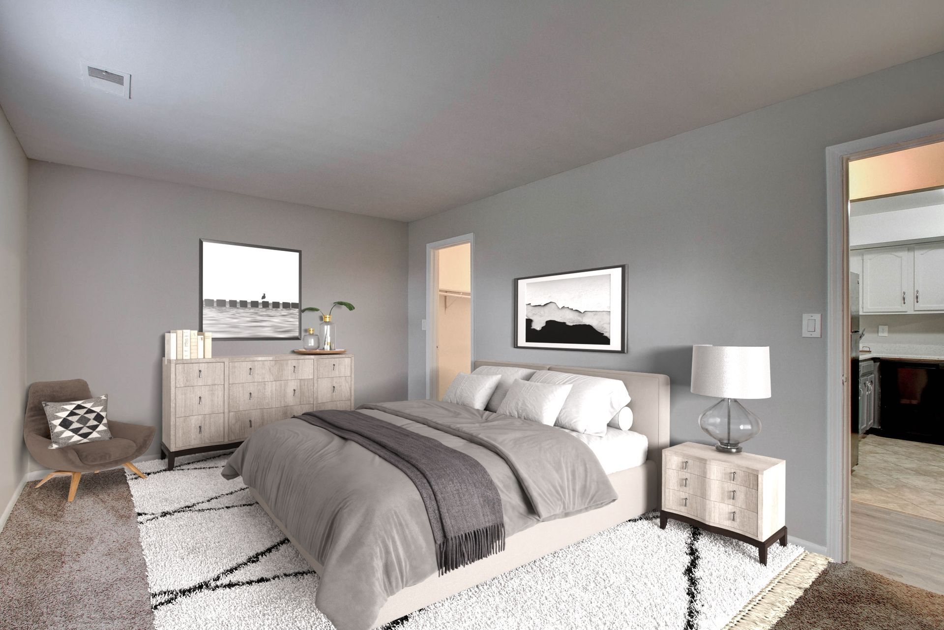 Bedroom with bed, dresser, and chair. Gray walls, white and gray rug, and artwork.