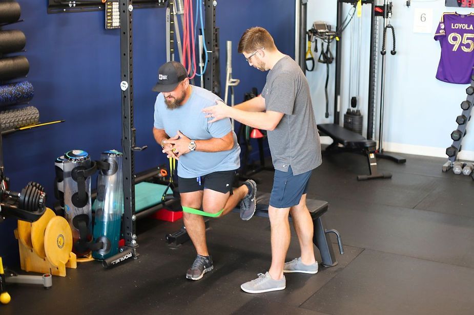 A man is doing exercises with a resistance band in a gym. A man is doing exercises with a resistance band in a gym.