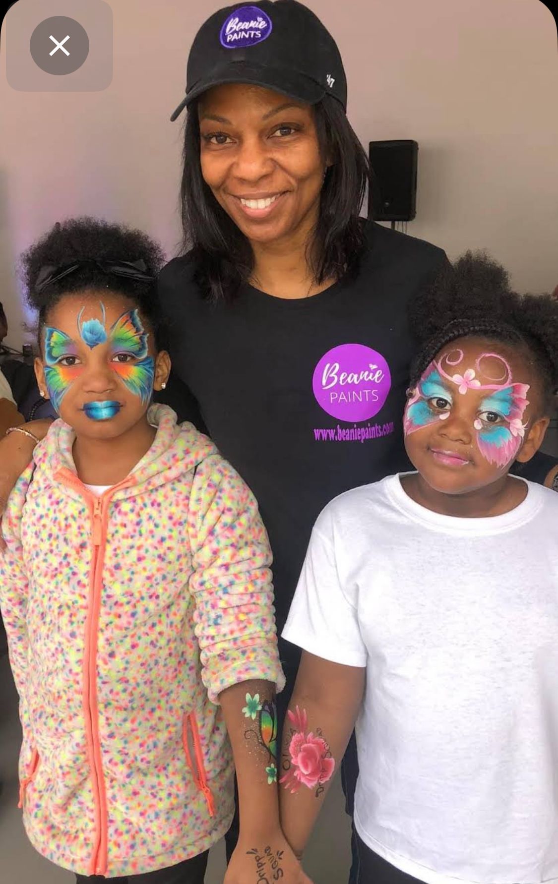 Owner of Beanie Paints with children's faces painted as butterflies