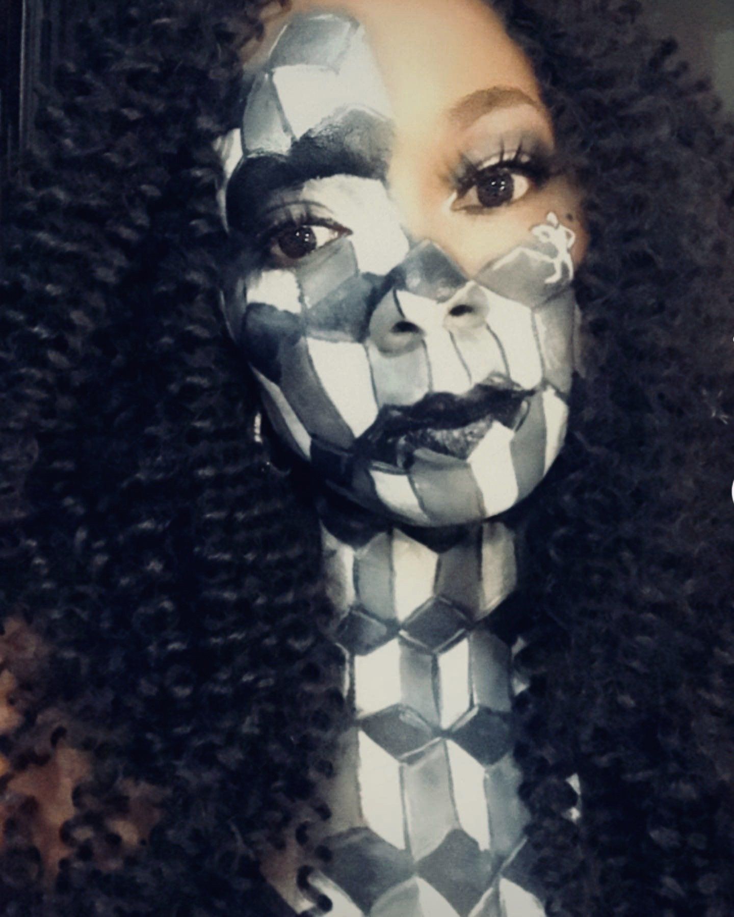 Portrait with black-and-white geometric face paint on a woman with curly hair