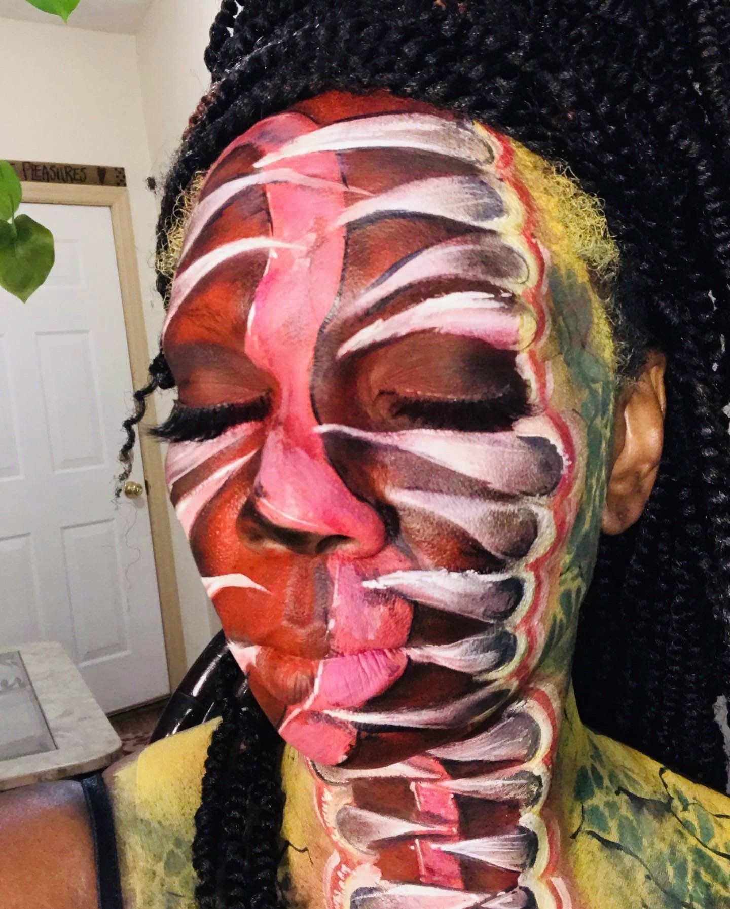 Close-up of a face painted with colorful abstract stripes and feather-like designs, eyes closed