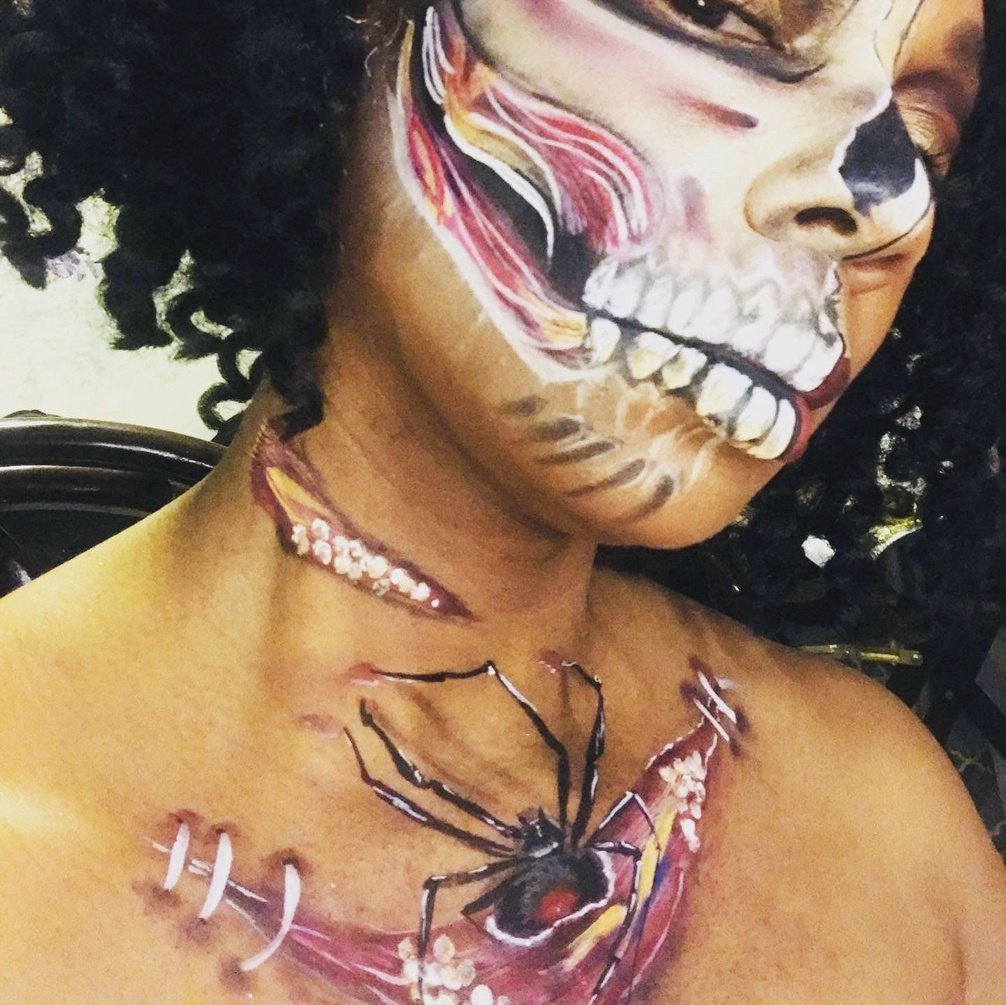 Person with elaborate skull face paint and spider chest makeup, close-up portrait