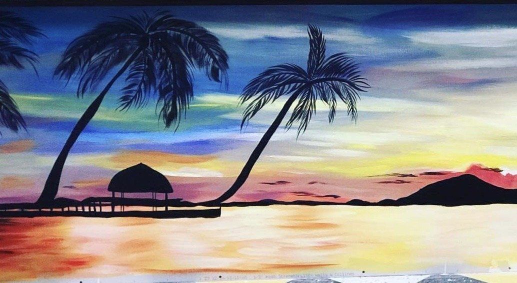 Tropical beach sunset with silhouetted palm trees, a hut, and colorful sky reflected on calm water