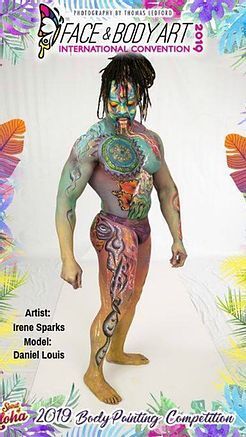 Body-painted figure posing in front of a colorful Face & Body Art convention poster.