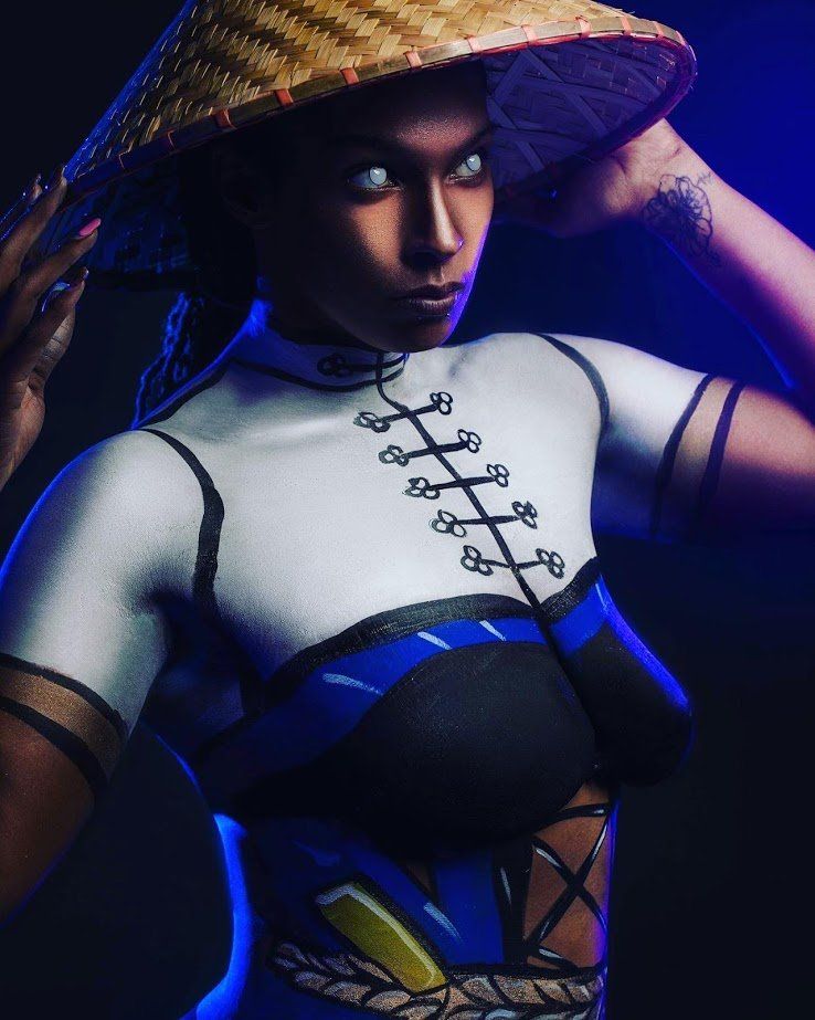 Stylized woman in a straw hat and blue-and-white outfit posing against a dark blue background