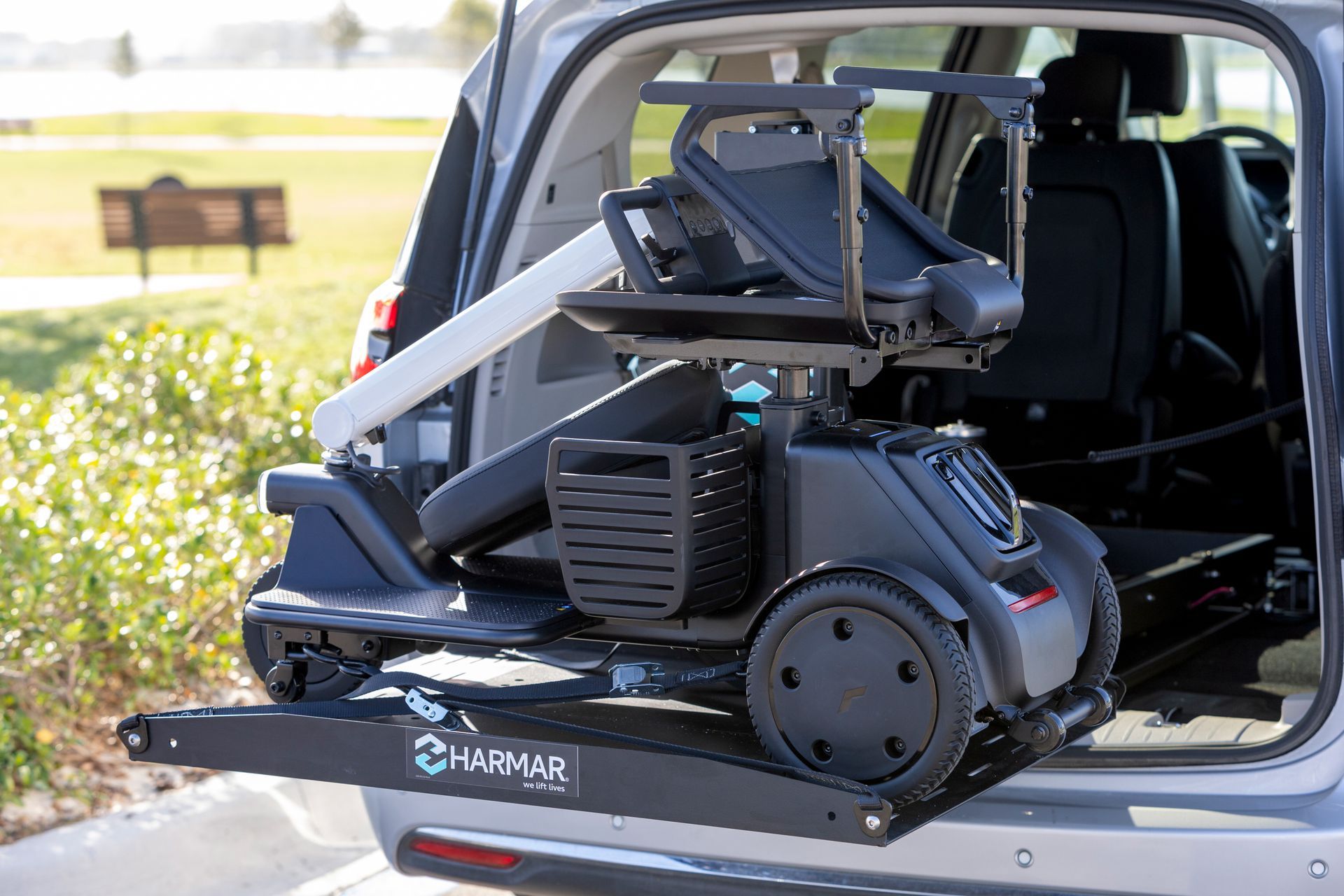 Motorized wheelchair secured in the open rear of a vehicle at a parking lot