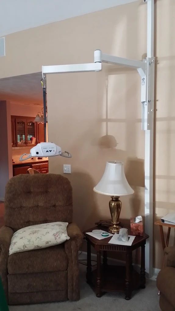Living room chair beside a side table with lamp, under a white ceiling-mounted frame