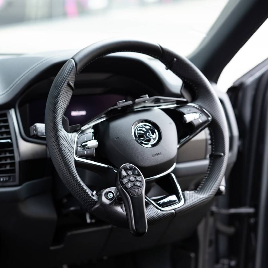 Close-up of a modern black car steering wheel with dashboard and open door visible