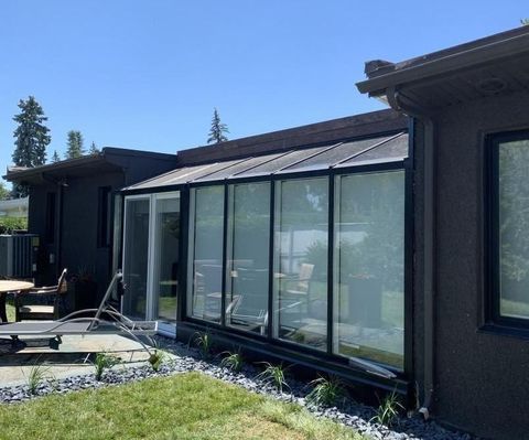 Une maison avec beaucoup de fenêtres et une table devant