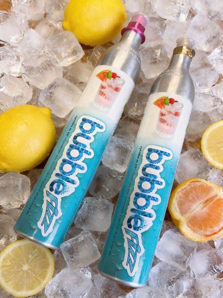 Deux boissons en bouteille turquoise sur glace avec des tranches de citron et d'orange.