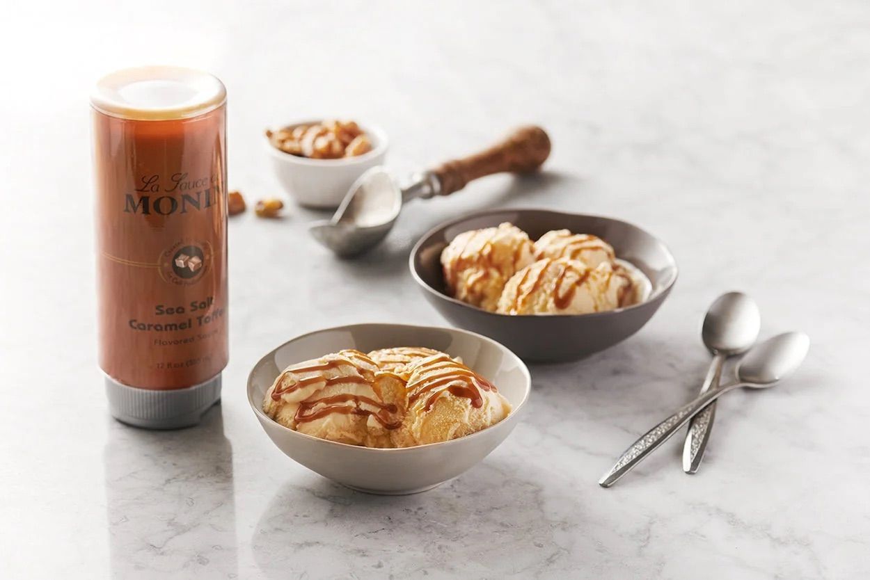 Bouteille de sirop Monin au caramel et sel de mer, étiquette orange et bouchon argenté