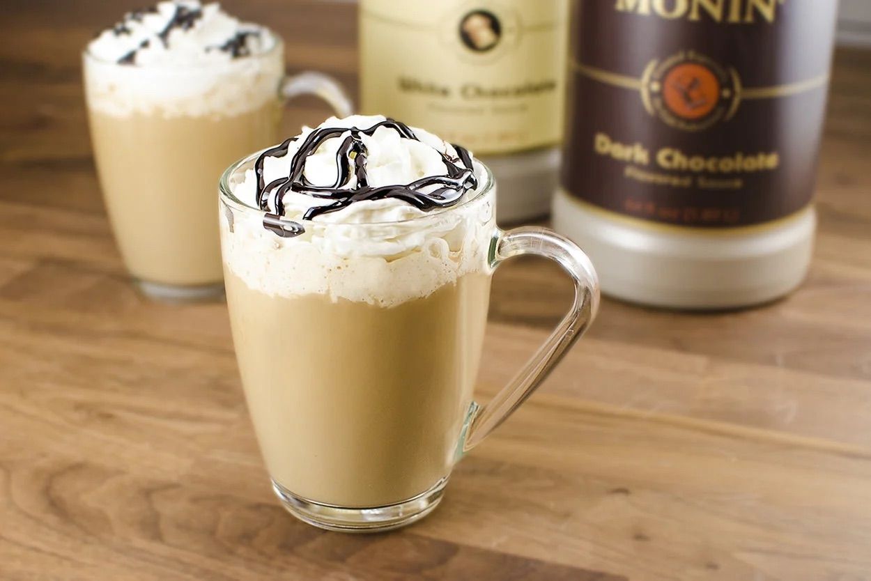 Bouteille de sirop de chocolat noir Monin avec étiquette brune et bouchon argenté sur fond blanc