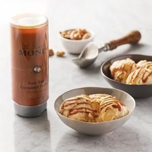 Des barres de dessert au chocolat et une boîte à goûter marron à côté de bols de viennoiseries tranchées sur une table blanche
