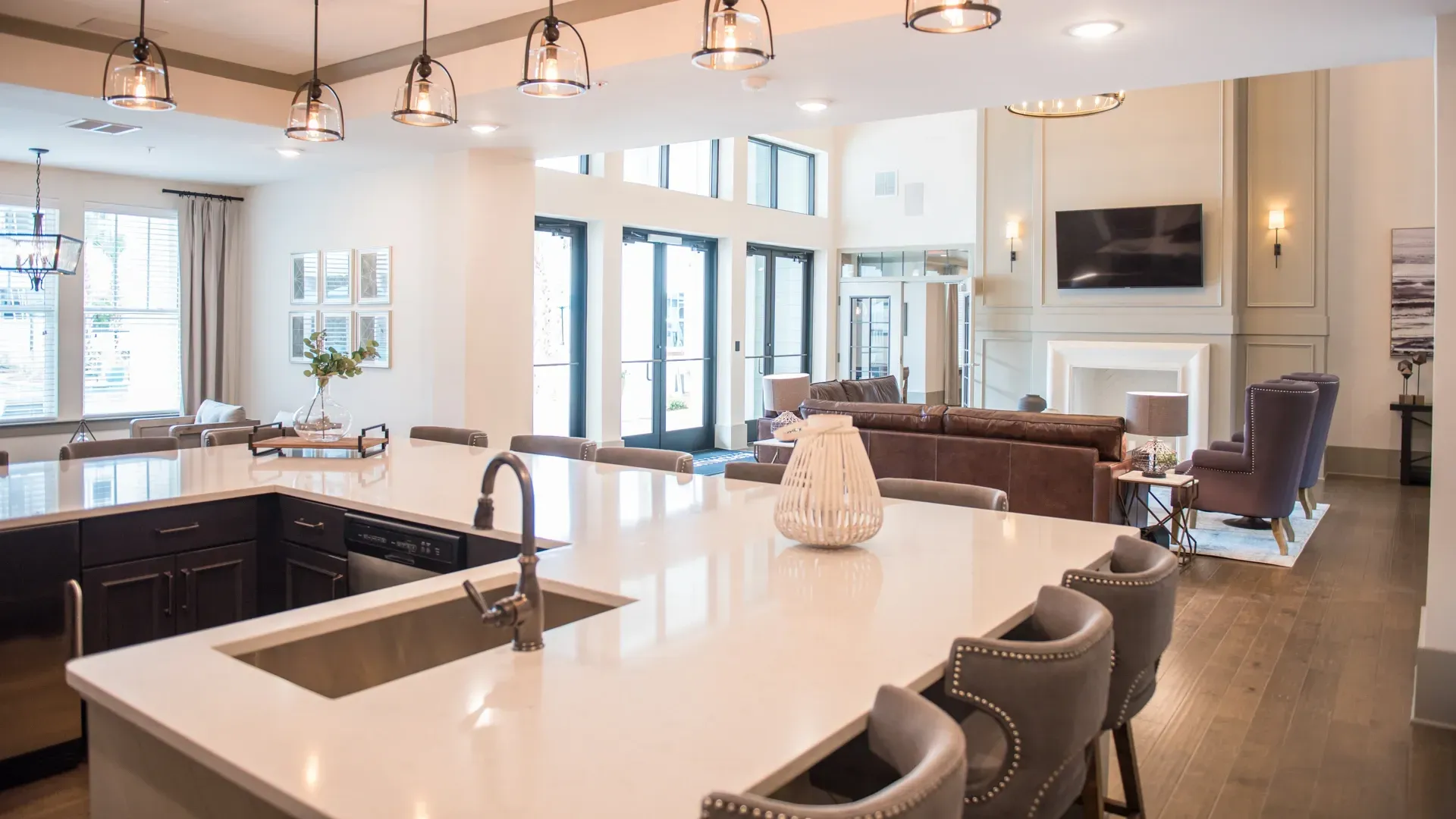 Clubhouse kitchen island and lounge area with fireplace and TV