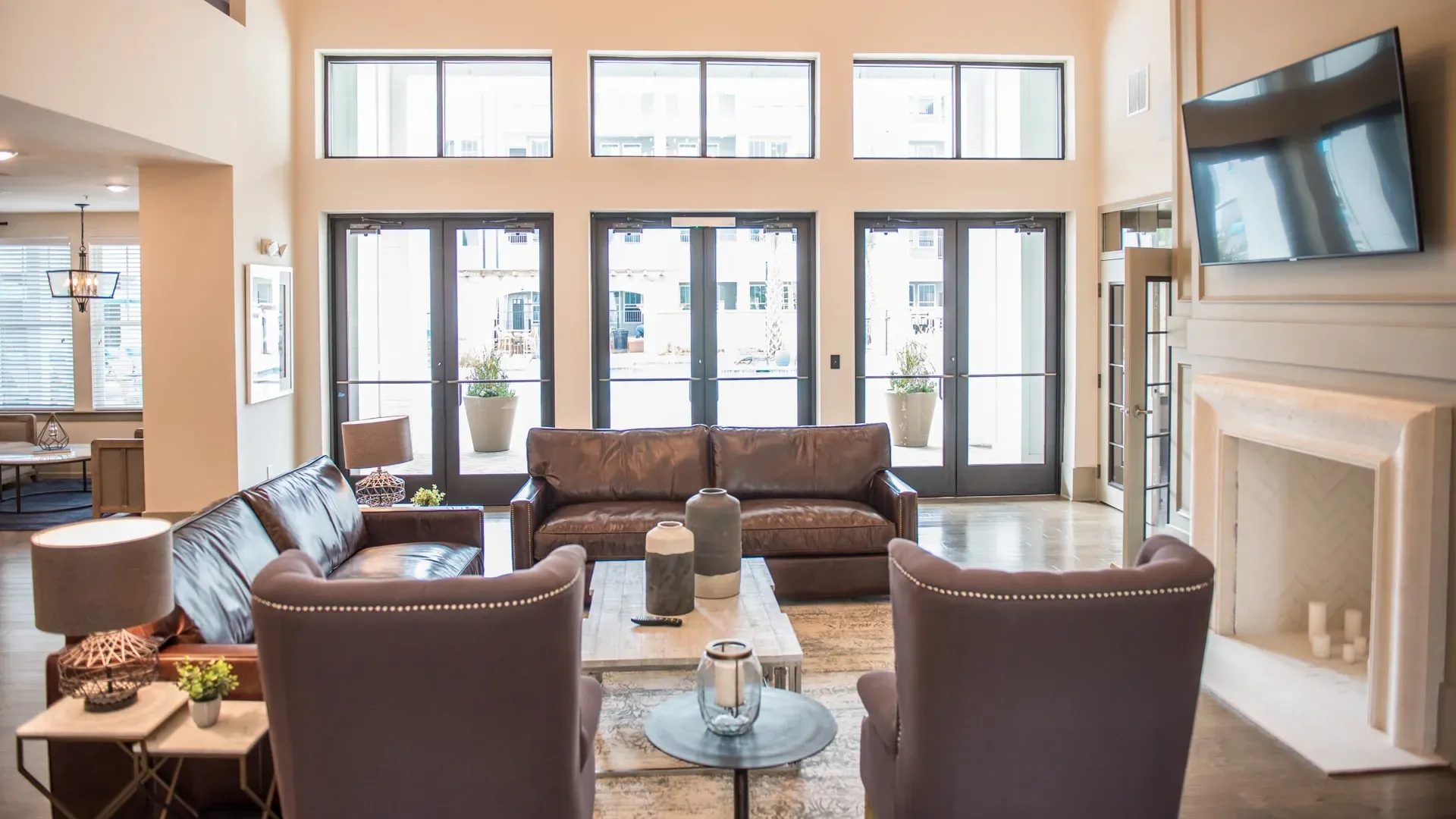 Lobby seating area with leather couches, armchairs, and a fireplace.