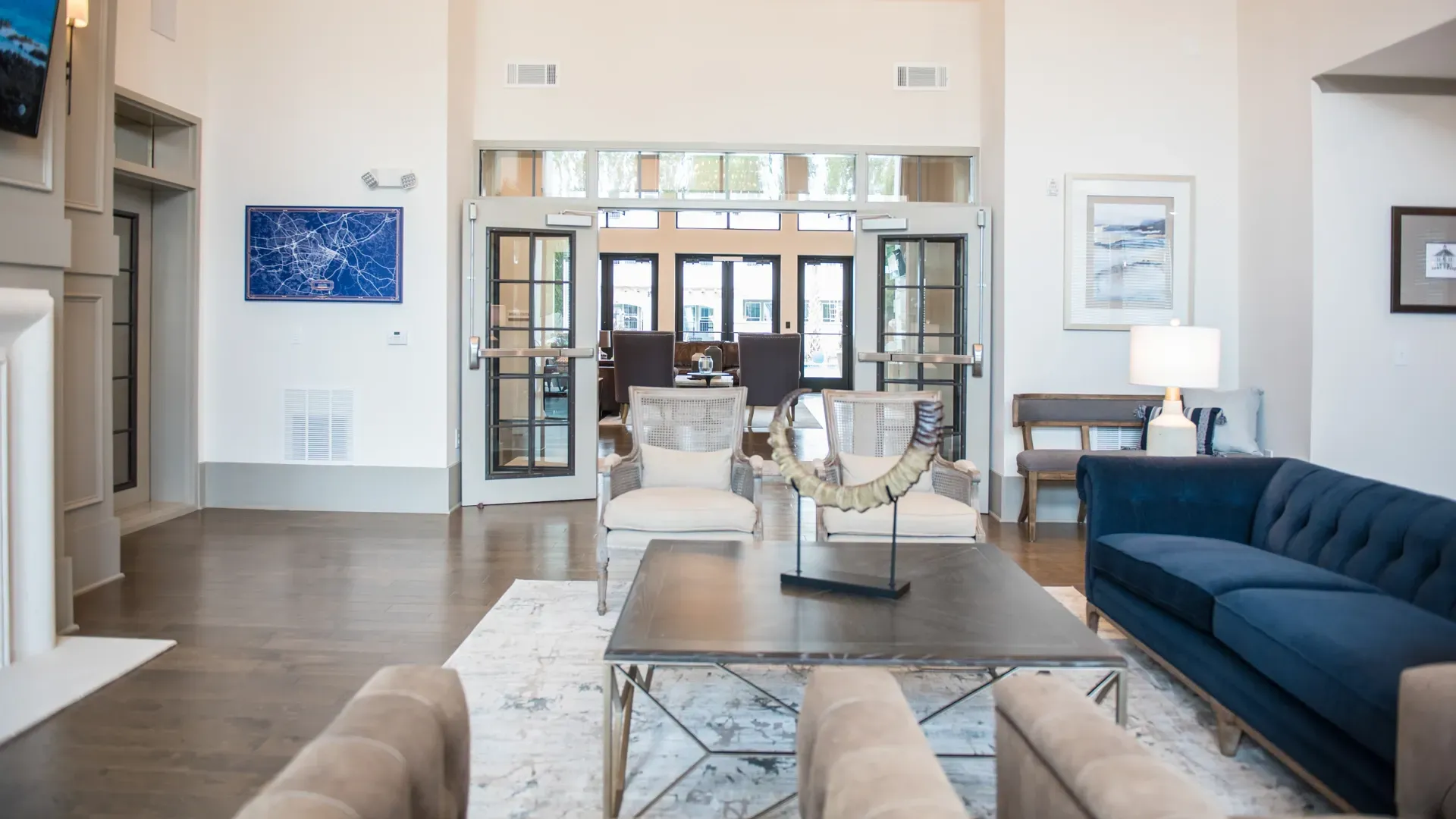 Lobby area with blue sofa, armchairs, coffee table, and artwork.