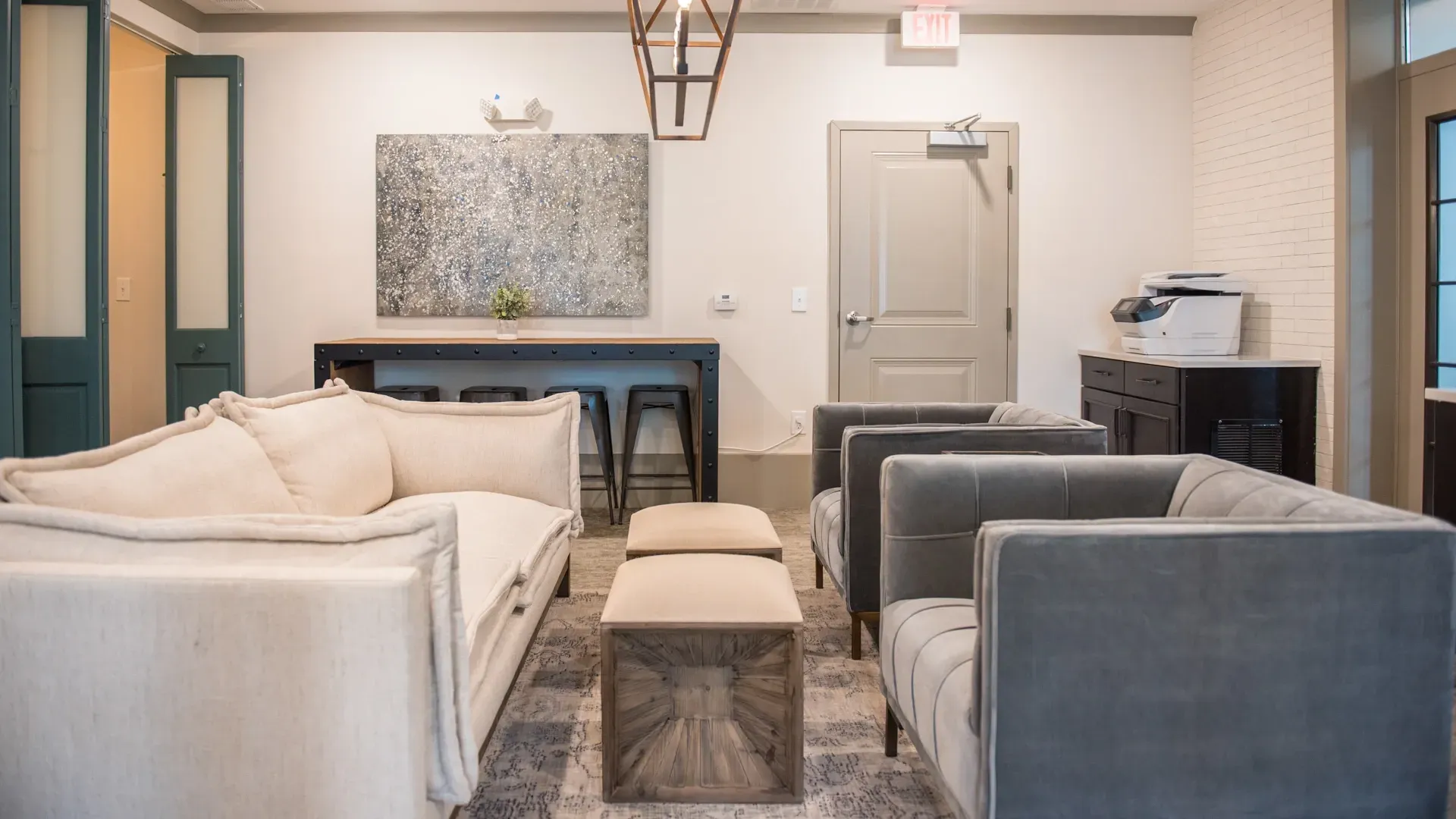 Seating area with couches, stools, and a printer.