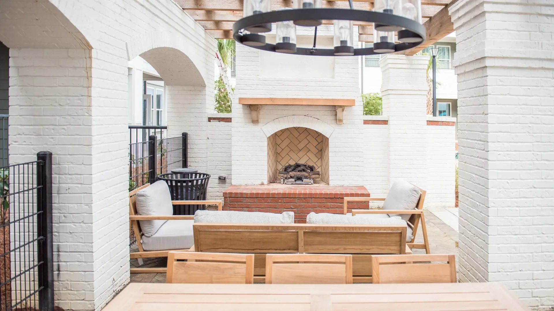 Outdoor seating area with a fireplace and chandelier.
