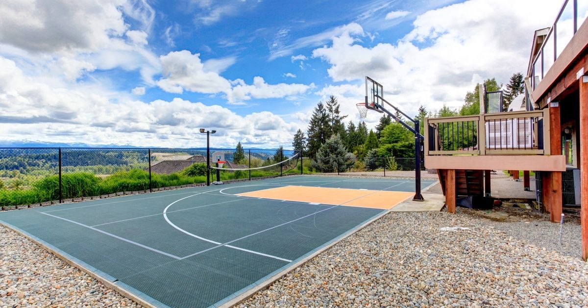 A beautiful Southern California home overlooking a cityscape and mountains. There's a large basketball court in the yard.