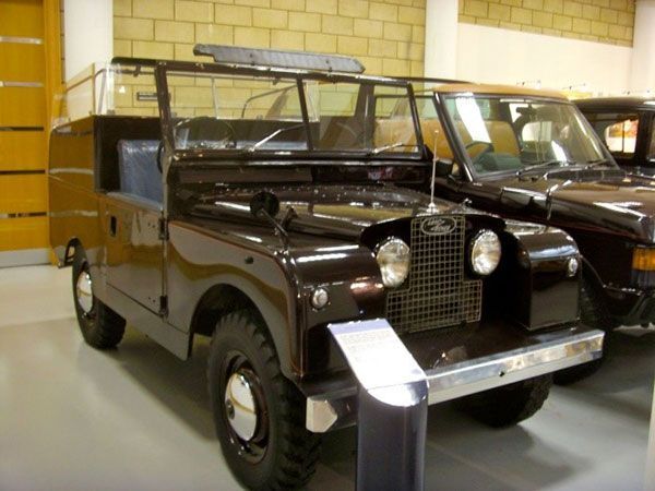 Vintage dark brown off-road vehicle displayed indoors in a museum or garage