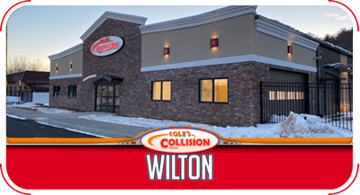 Wilton Collision shop exterior at dusk with brick facade and snowy parking lot