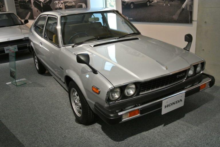 Silver vintage Honda coupe displayed in a showroom, front three-quarter view