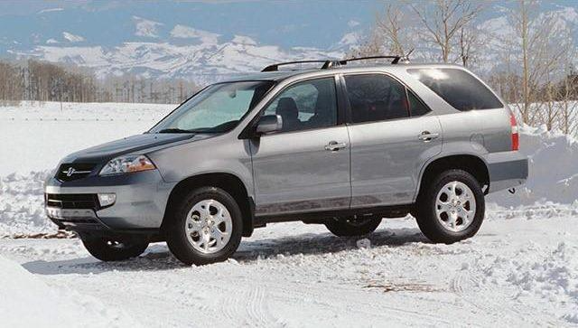 Silver SUV parked on a snowy field under a cloudy winter sky