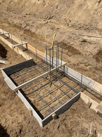 Concrete foundation rebar formwork in a dirt excavation site