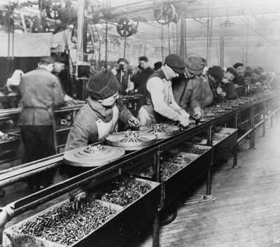 Factory workers sorting nuts and bolts on an assembly line