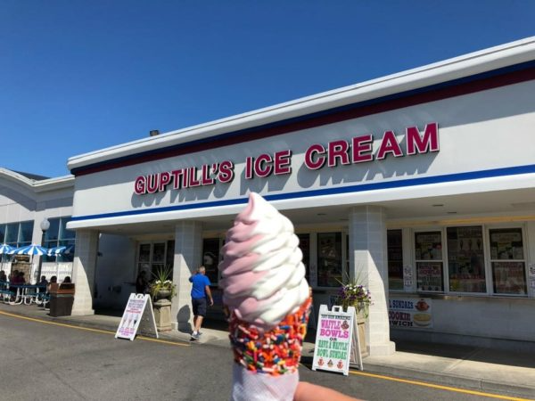 Soft-serve cone in front of Guptill's Ice Cream storefront on a sunny day