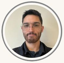 Man with glasses and beard in a circular profile photo against a light background