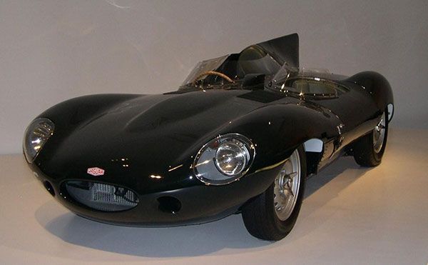Black vintage sports car on display in a showroom or museum.