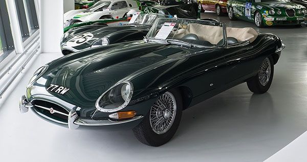 Classic black Jaguar E-Type sports car displayed in a showroom