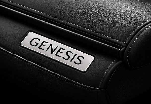 Close-up of black leather car seat with a silver GENESIS badge