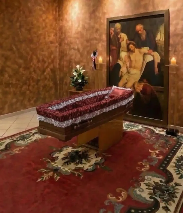 Una sala interna con un dipinto raffigurante Gesù deposto, posto sopra un tappeto decorato.