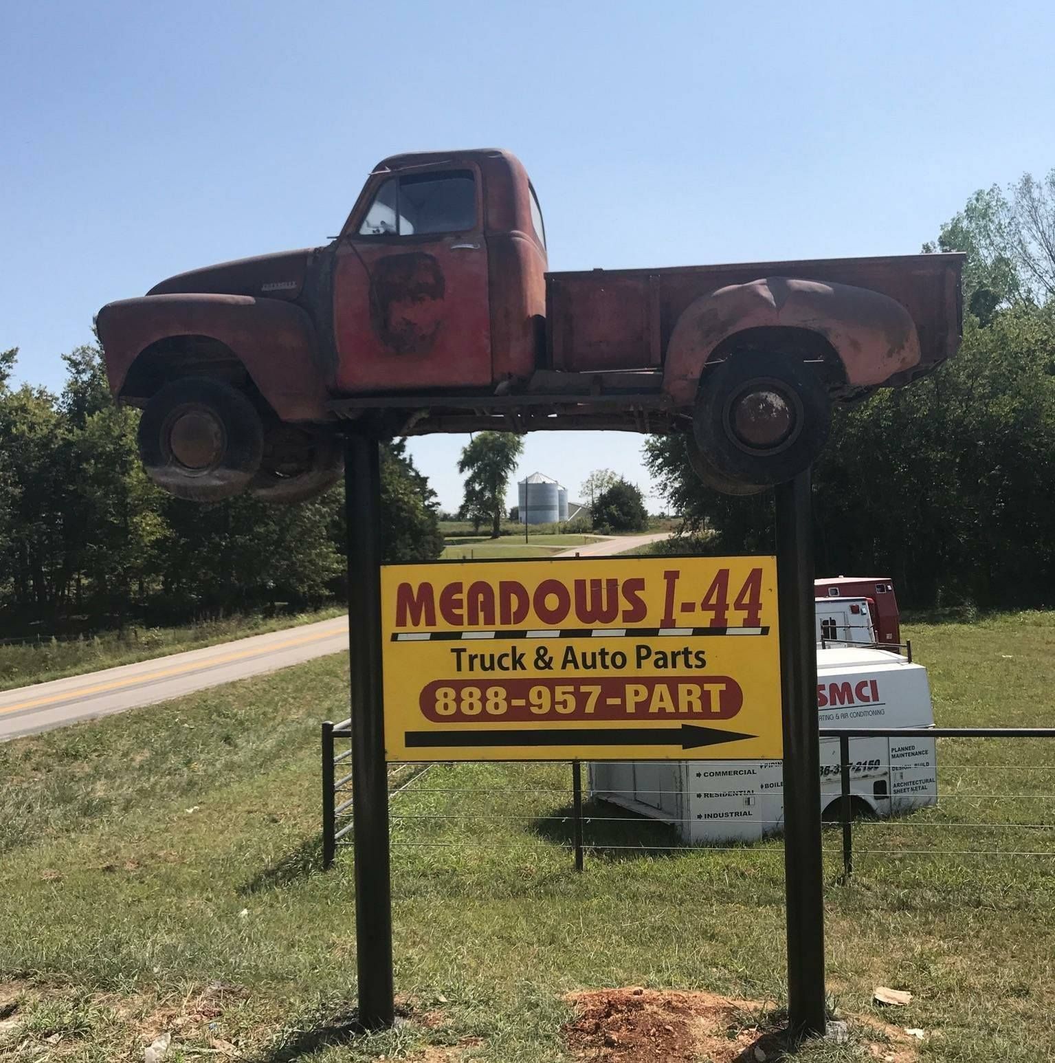 A yellow sign for mendows i-44 truck and auto parts