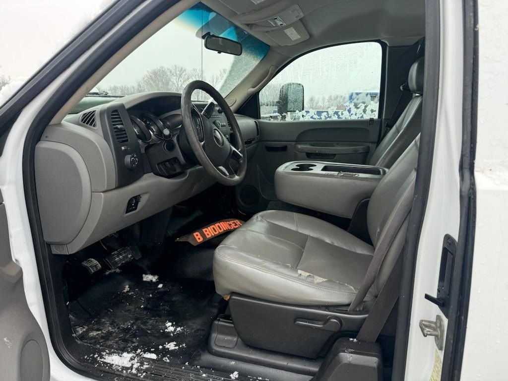 The interior of a white truck with the door open.