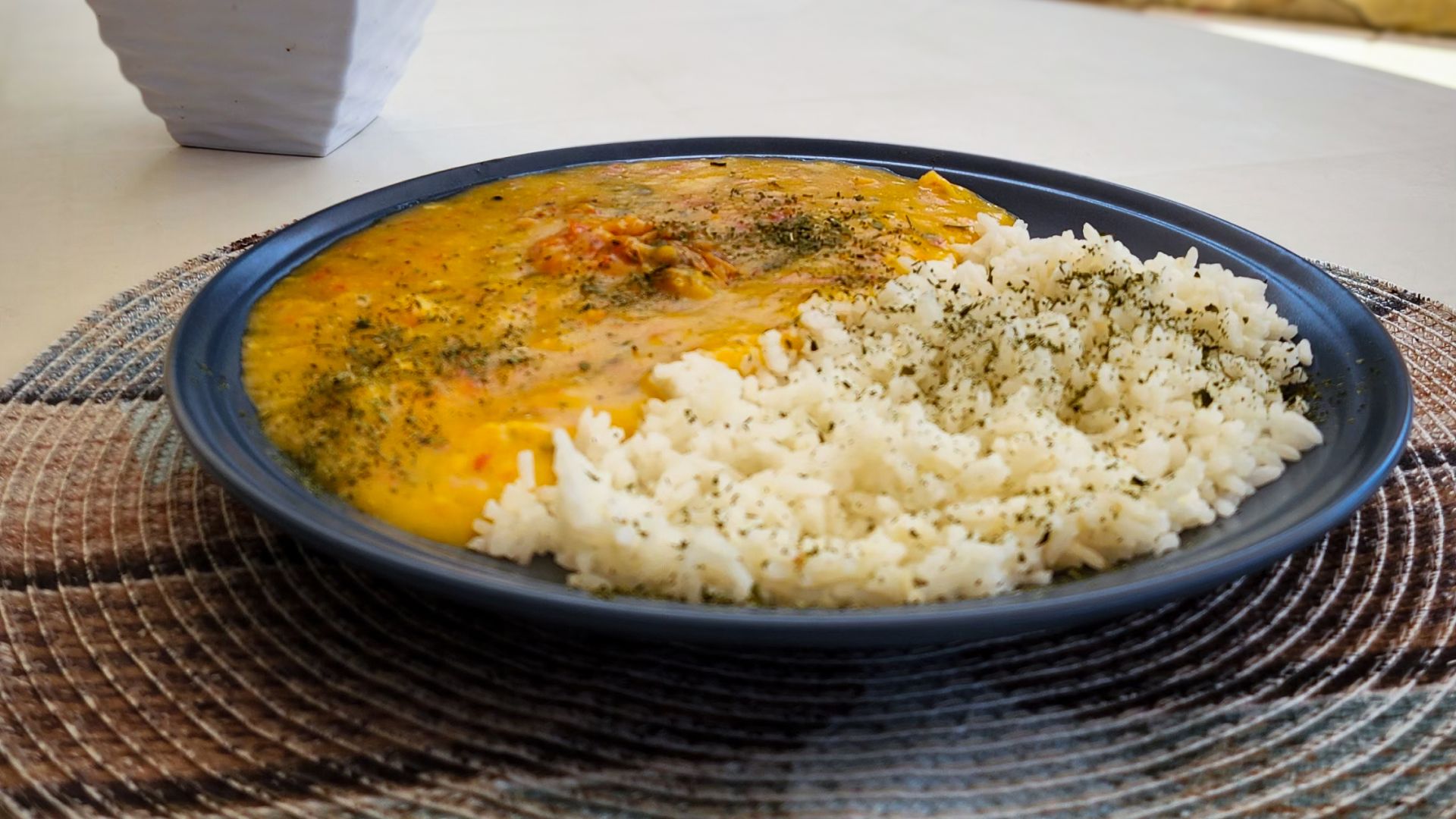 Um prato de comida com arroz e molho sobre uma mesa. - Pizzato Praia Hotel