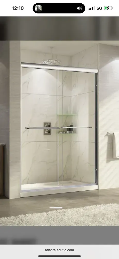 Modern glass shower enclosure with beige tile walls and a tiled bathroom floor