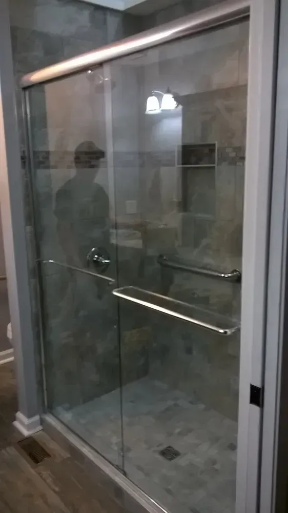 Glass shower enclosure with chrome handles in a bathroom, seen from outside