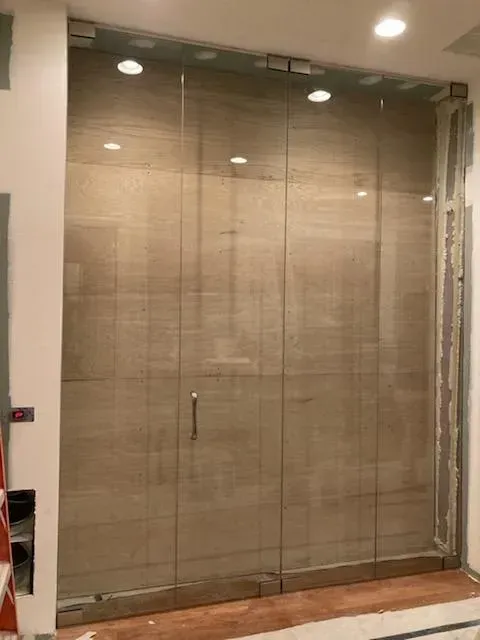 Glass storefront with woven blinds and a wooden base in a hallway interior