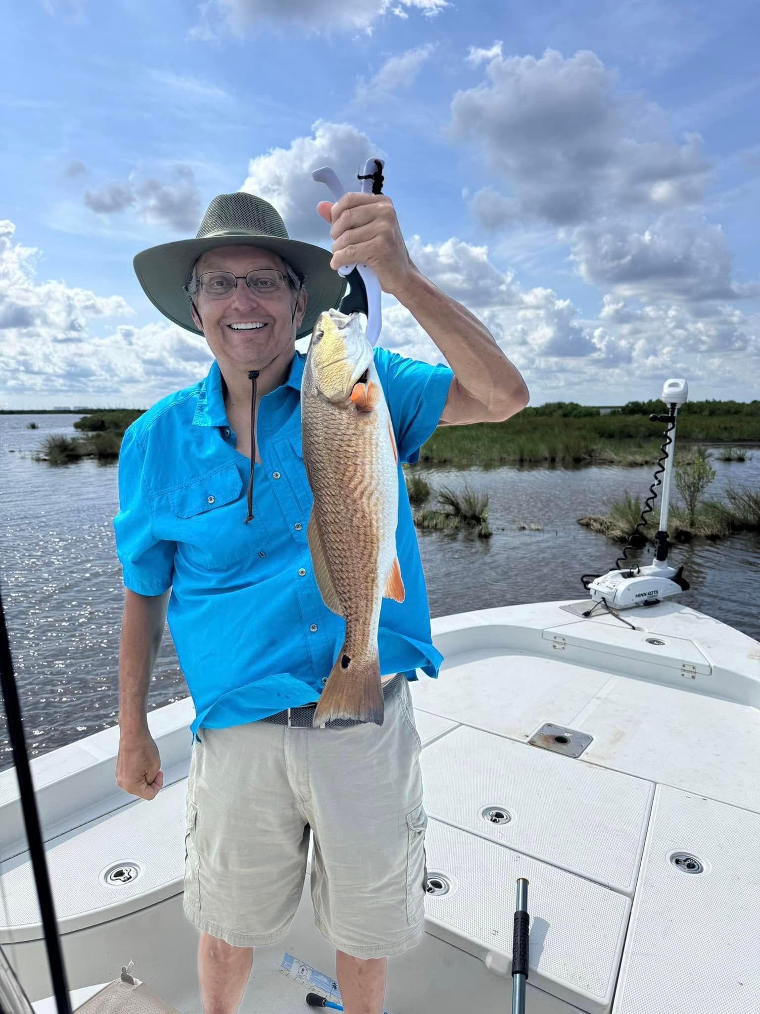 A man is holding a fish on a boat.