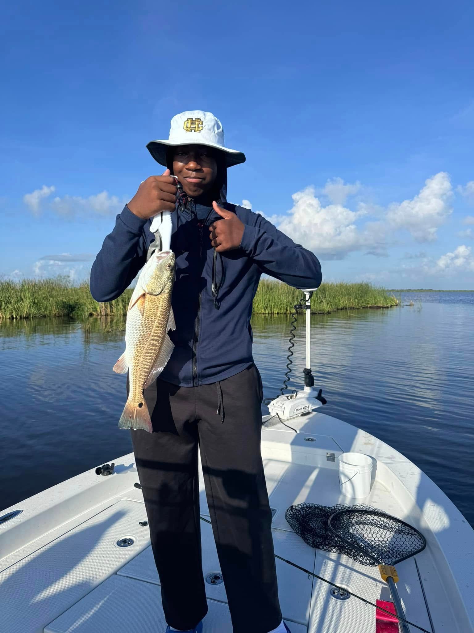 A man is standing on a boat holding a fish.
