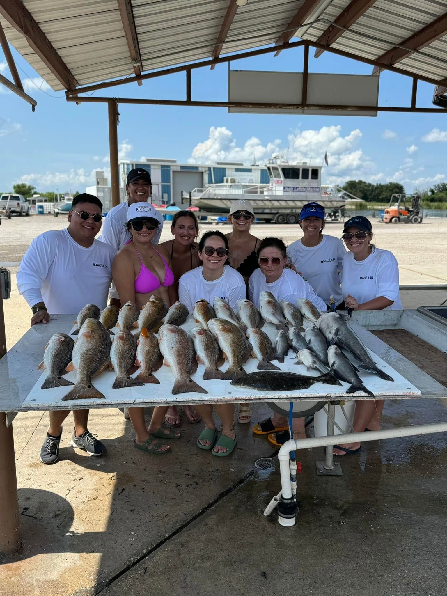 A group of people standing around a table full of fish.