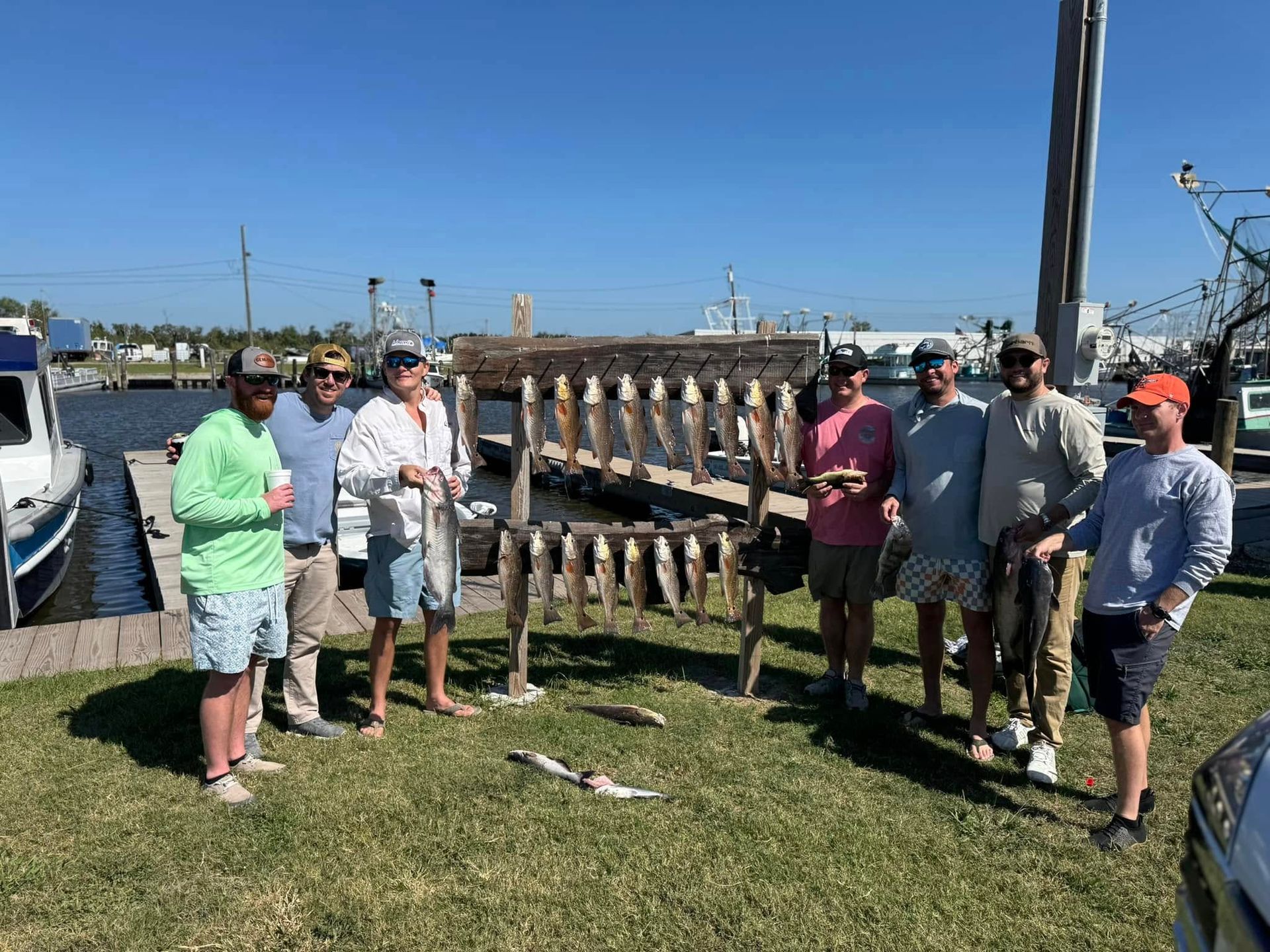 A group of men are standing in front of a display of fish.